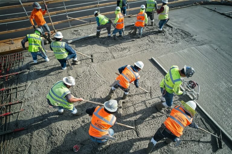 Workers leveling freshly poured concrete on a slab
