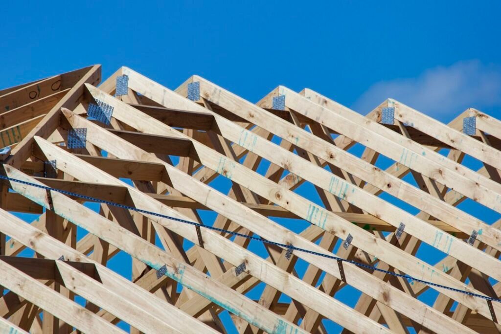 Residential house under construction with visible timber framing and roof trusses